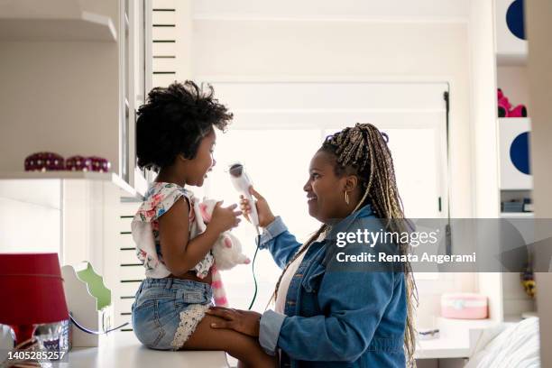 woman drying her niece's hair in the bedroom - aunt niece stock pictures, royalty-free photos & images