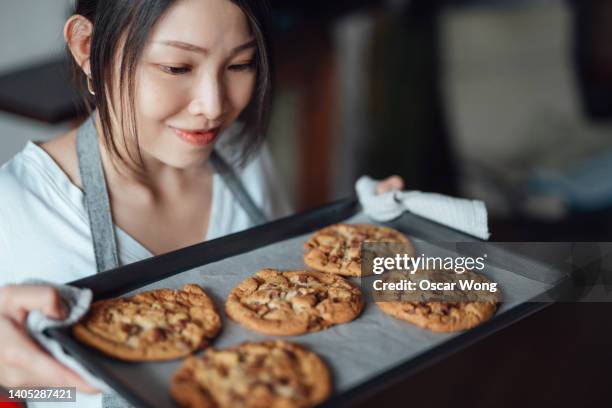 young woman baking cookies at home - baking tray stock pictures, royalty-free photos & images