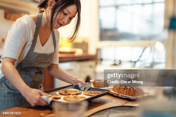 young woman baking cookies at home - baking ストックフォトと画像