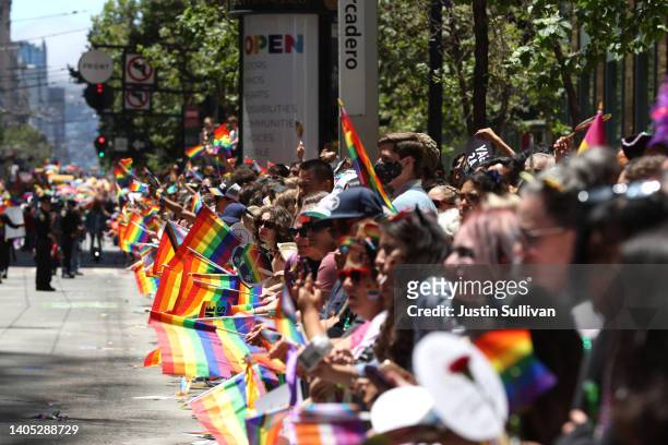 Parade goers hold Pride flags as they line the route of the 52nd Annual San Francisco Pride Parade and Celebration on June 26, 2022 in San Francisco,...