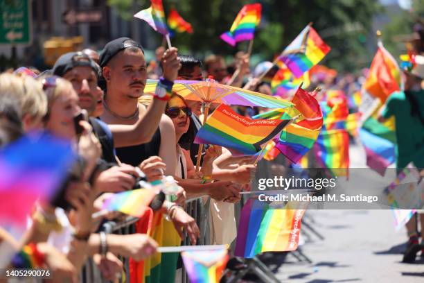 People wave Pride flags as they watch the New York City Pride Parade on Fifth Avenue on June 26, 2022 in New York City. The 53rd annual NYC Pride...