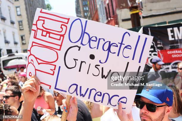 People hold up signs as they watch the New York City Pride Parade on Eighth Street on June 26, 2022 in New York City. The 53rd annual NYC Pride March...