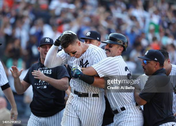 Aaron Judge of the New York Yankees is greeted by his team after hitting a walk off tenth inning three run home run to win the game 6-3 against the...