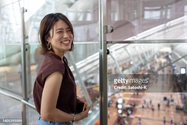 mujer sonriendo en el aeropuerto antes de volar - manga corta fotografías e imágenes de stock
