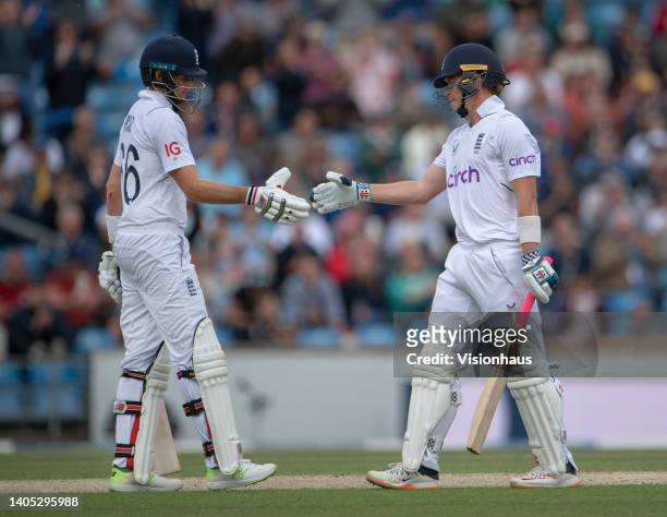 Joe Root of England and team mate Ollie Pope shake hands after Pope reaches 50 during day four of the Third Test Match between England and New...