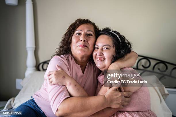 portrait of mother and psychomotor retardation daughter at home - teenager cerebral palsy stock pictures, royalty-free photos & images