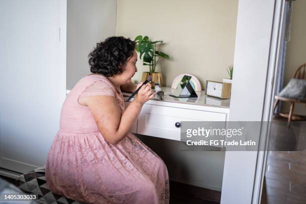 psychomotor retardation girl doing her makeup at home - chubby teenage girl imagens e fotografias de stock