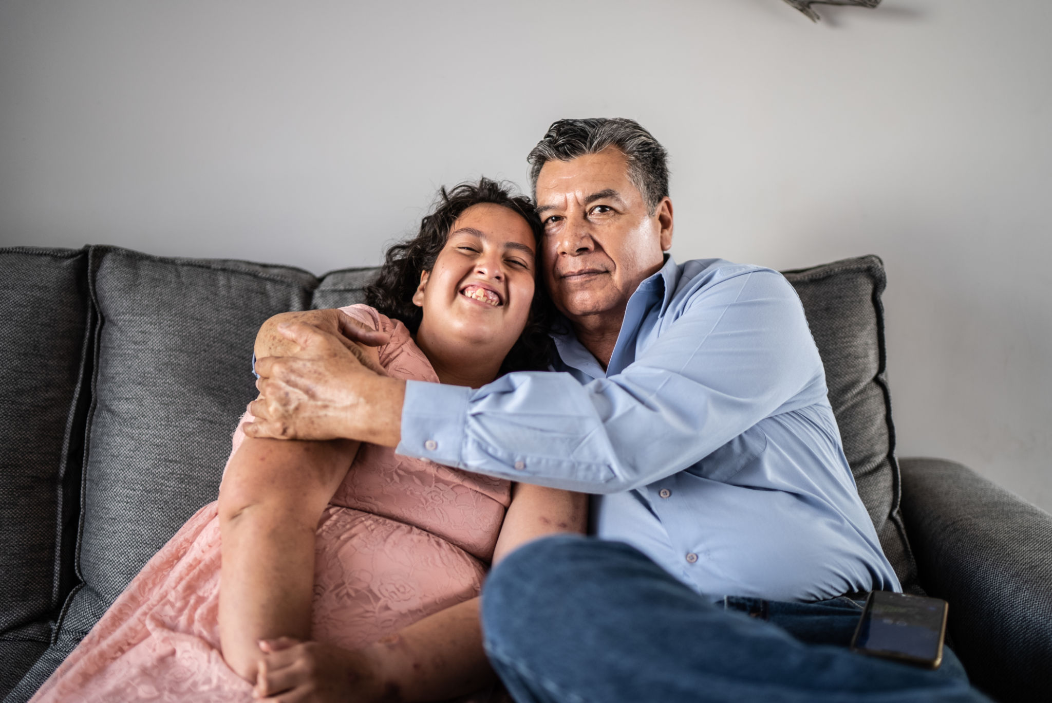 Portrait of father and psychomotor Intellectual disability daughter sitting on the sofa at home Portrait of father and psychomotor Intellectual disability daughter sitting on the sofa at home