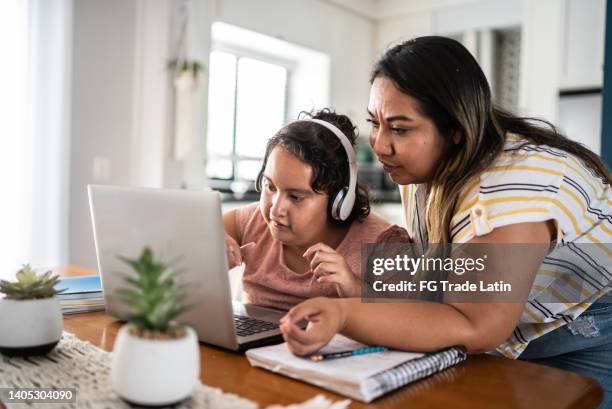 mother helping psychomotor intellectual disability girl using laptop studying at home - disability computer stock pictures, royalty-free photos & images