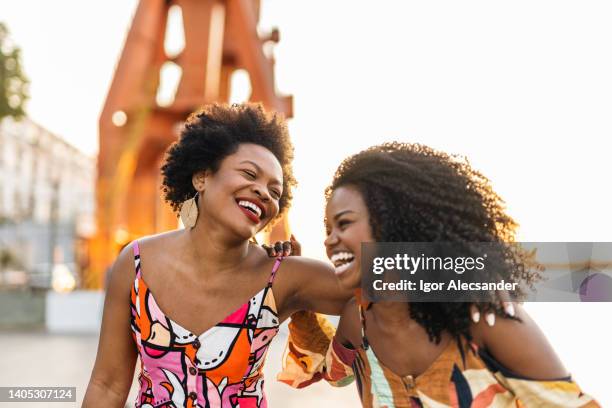 mulheres sorridentes na cidade ao pôr do sol - liberdade financeira - fotografias e filmes do acervo