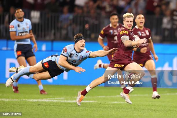 Cameron Munster of the Maroons breaks away from Cameron Murray of the Blues to score a try during game two of the State of Origin series between New...