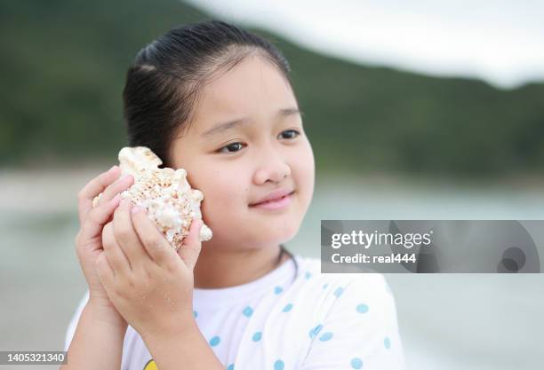 niños jugando en la playa - caracola concha de mar fotografías e imágenes de stock