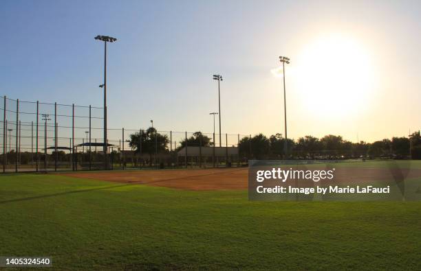 empty baseball diamond at dusk - sports field fence stock pictures, royalty-free photos & images