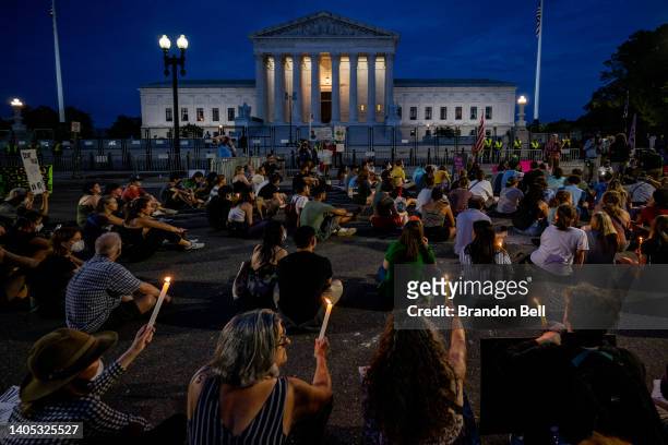 Protesters attend a candlelight vigil in front of the U.S. Supreme Court to denounce the court's decision to end federal abortion rights protections...