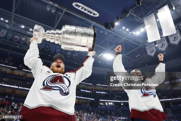 Gabriel Landeskog of the Colorado Avalanche lifts the Stanley Cup as Erik Johnson celebrates after defeating the Tampa Bay Lightning 2-1 in Game Six...