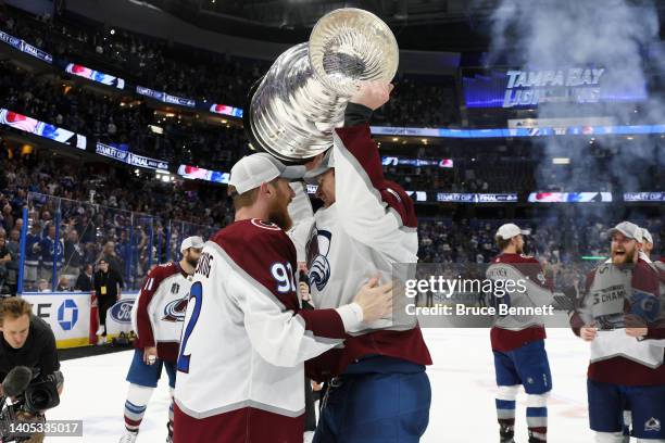 Erik Johnson of the Colorado Avalanche lifts the Stanley Cup in celebration with Gabriel Landeskog after defeating the Tampa Bay Lightning 2-1 in...