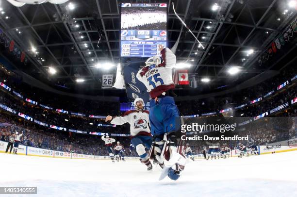 Goaltender Darcy Kuemper of the Colorado Avalanche tosses his stick into the air to celebrate as Devon Toews joins him in celebration shortly after...