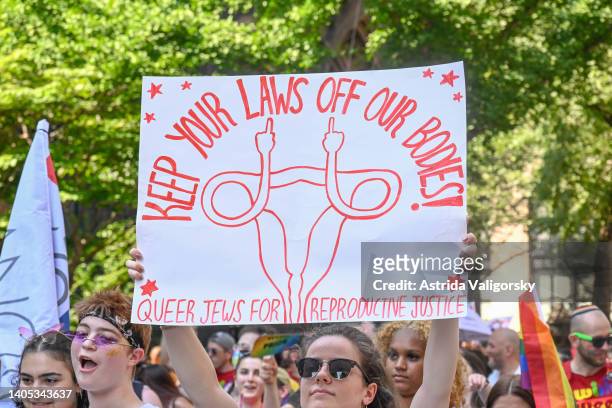 Member of Queer Jews for Reproductive Justice holds a sign reading "keep your laws off our bodies!" in protest of the recent US Supreme Court ruling...