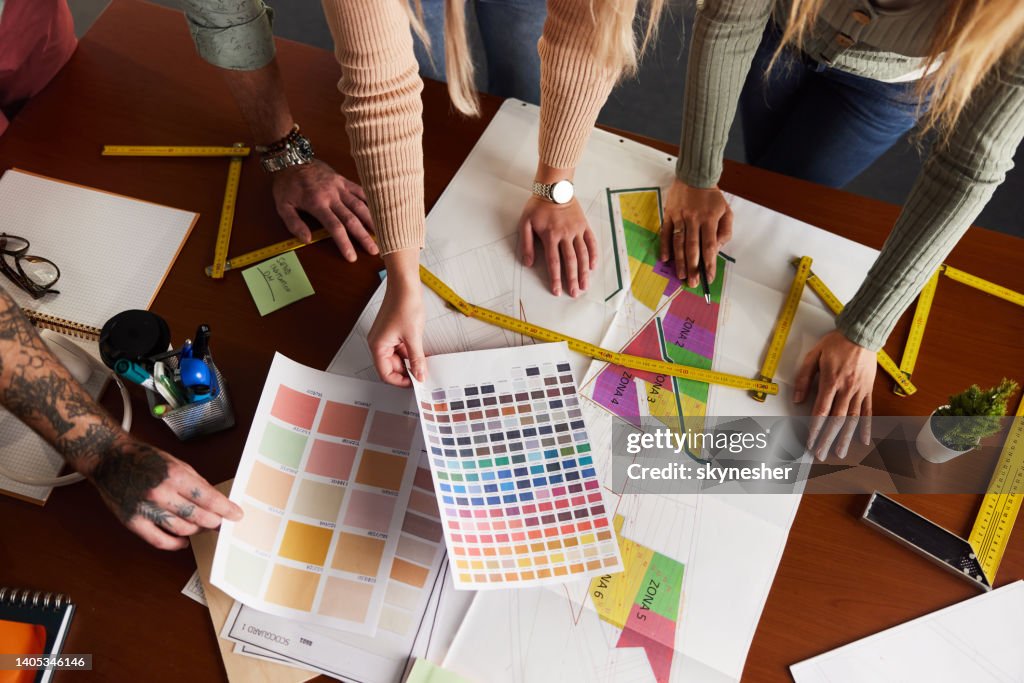 Obige Ansicht von Designern, die im Büro an Plänen arbeiten.