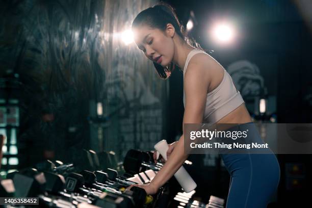 fitness staff cleaning exercise machines alcohol sanitizer spray at the gym. new normal concept. - gym reopening stock pictures, royalty-free photos & images