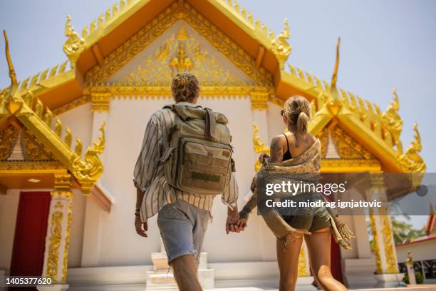unkenntliches reisepaar, das den thailändischen tempel besucht - asien tempel stock-fotos und bilder