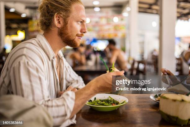caucasian man eating thai food with chopsticks - thai food stock pictures, royalty-free photos & images