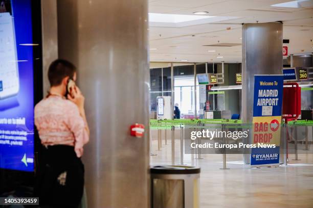 Woman talks on the phone next to Ryanair counters at Adolfo Suarez Madrid- Barajas Airport, during the fourth day of strike of the Irish company, on...