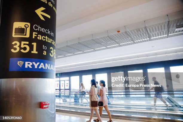 Two women walk next to a sign indicating Ryanair counters at Adolfo Suarez Madrid- Barajas Airport, during the fourth day of strike of the Irish...