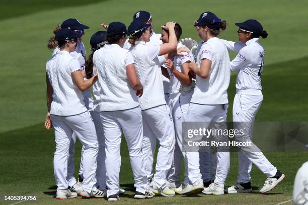 Issy Wong of England celebrates with teammates after bowling out Laura Wolvaardt of South Africa during Day One of the First Test Match between...