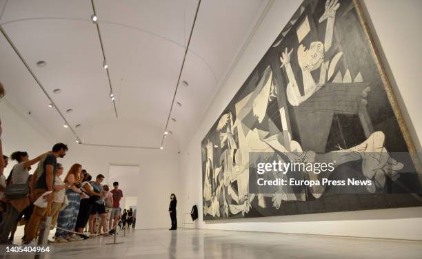 Attendees look at the Guernika painting after a peace action by activists at the Reina Sofia Museum on June 27 in Madrid, Spain. With this action,...