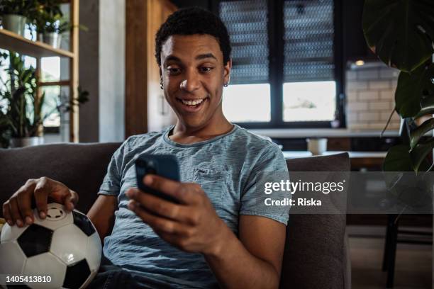 appassionato di calcio che utilizza l'app mobile per le scommesse - net sports equipment foto e immagini stock