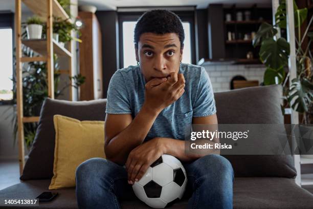 nervous young man watching soccer game - championship final round stock pictures, royalty-free photos & images