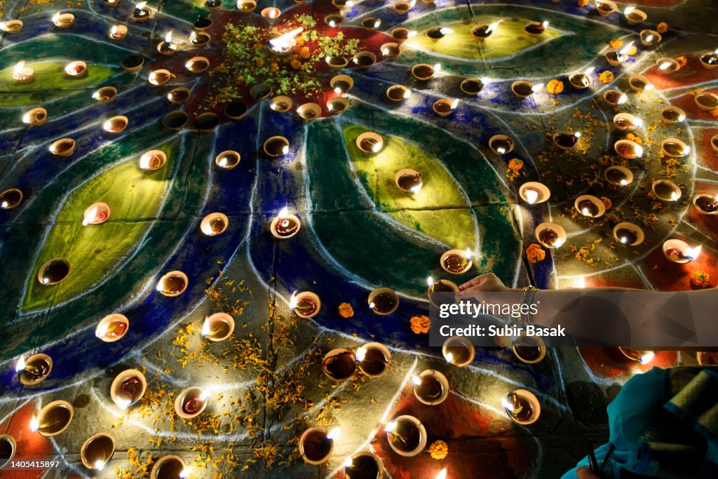 Woman lighting diyas during diwali,Varanasi,Uttar Pradesh,India.
