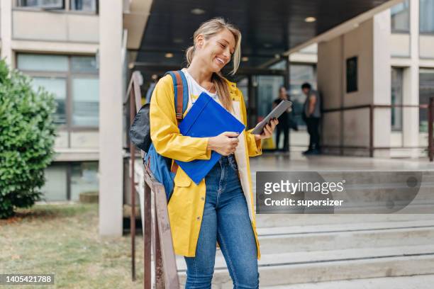 chatting with friends while waiting for the next class - female rain coat stock pictures, royalty-free photos & images