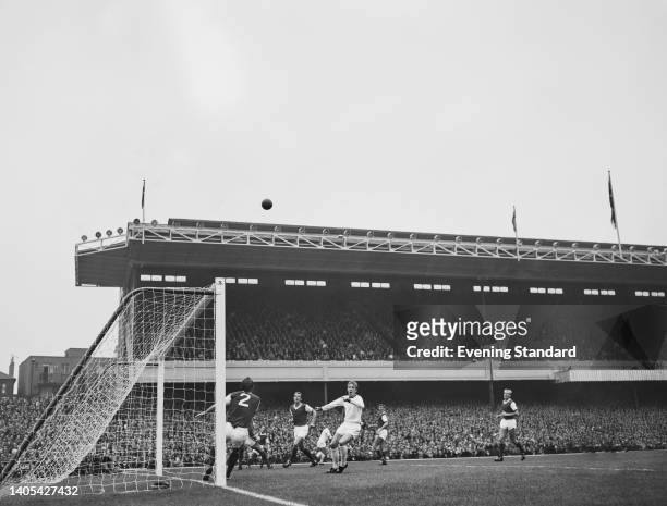 British footballer Denis Law, Manchester United centre forward, watches the ball in flight near the Arsenal goal during the English League Division...