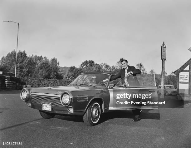 British journalist Robert Walling, Evening Standard motoring correspondent, poses by the open door of a Chrysler Turbine Car, a two-door car powered...