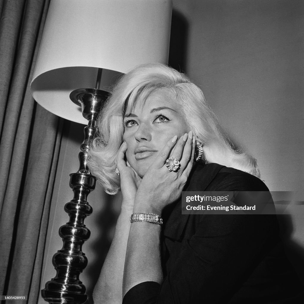 British actress and singer Diana Dors , her chin resting in her... News