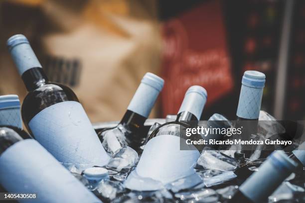 wine bottles chilling with ice - ice bucket stockfoto's en -beelden
