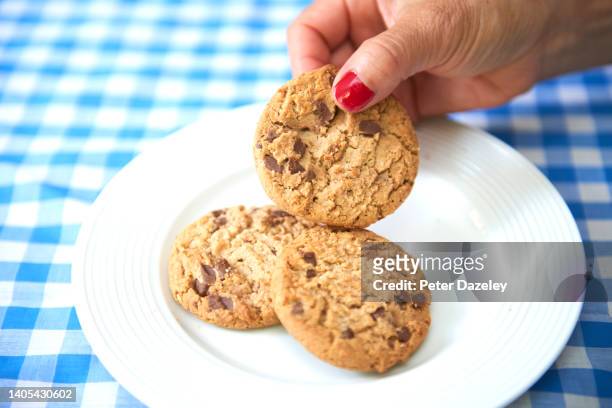 woman taking cookie - shortbread stock pictures, royalty-free photos & images
