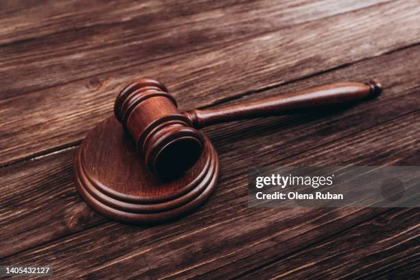 brown judge's gavel over stand against wooden background. - sentencing fotografías e imágenes de stock
