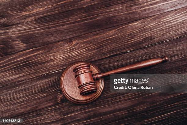brown judge's gavel over stand against wooden background with space for text. - in case of discomfort fotografías e imágenes de stock