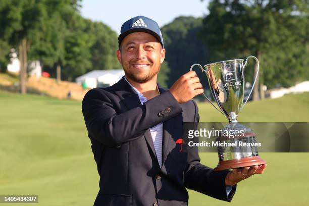 Xander Schauffele of the United States poses with the trophy on the 18th green after winning the Travelers Championship at TPC River Highlands on...