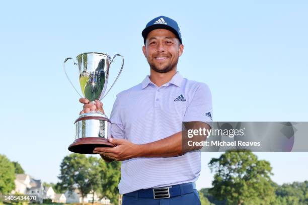 Xander Schauffele of the United States poses with the trophy on the 18th green after winning the Travelers Championship at TPC River Highlands on...