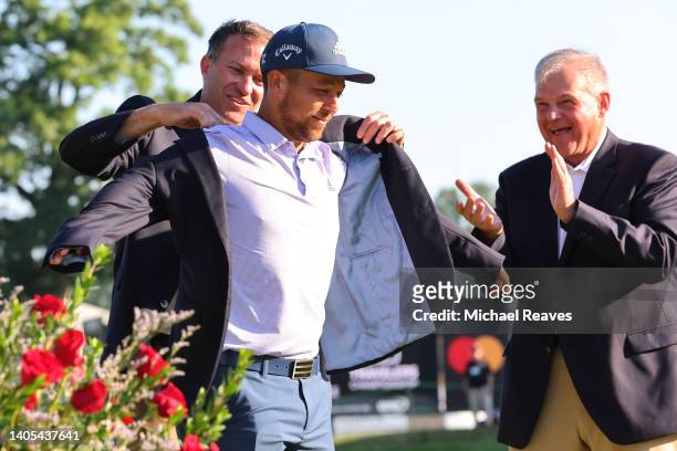Xander Schauffele of the United States is presented the winners jacket during the trophy presentation after winning the Travelers Championship at TPC...