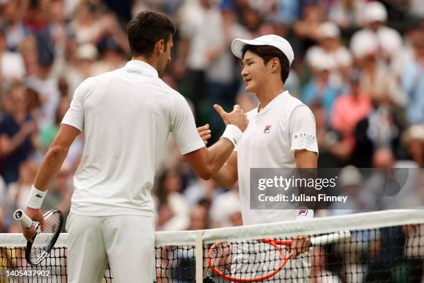 Novak Djokovic of Serbia interacts with Soonwoo Kwon of South Korea after winning their Men's Singles First Round match during Day One of The...