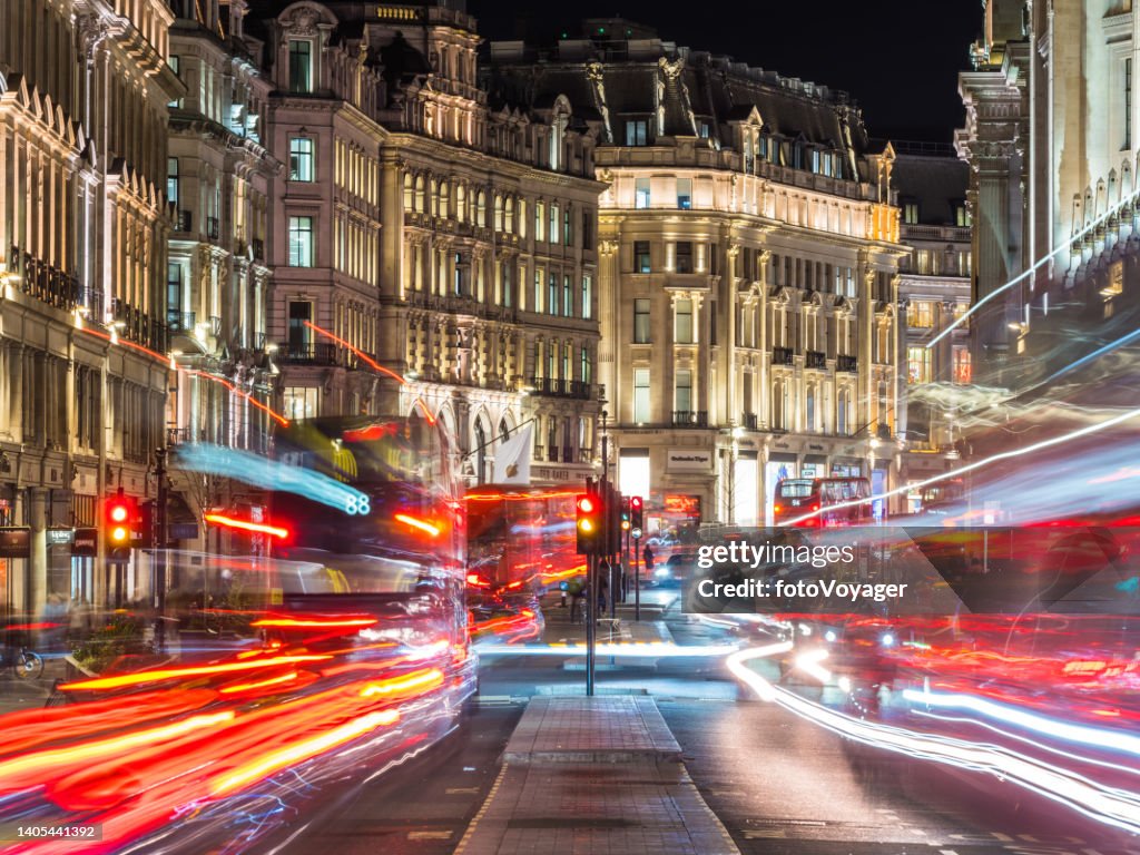London Regent Street buses zooming past shops illuminated at night