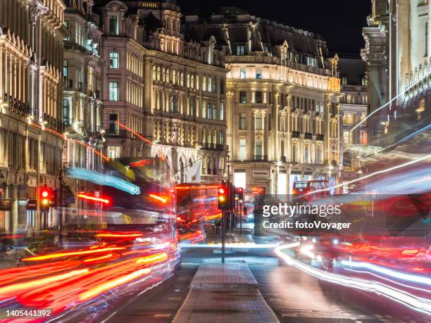 london regent street buses zooming past shops illuminated at night - capitalism stock pictures, royalty-free photos & images