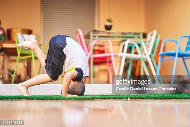 energetic boy doing somersault on backyard - somersault stock pictures, royalty-free photos & images