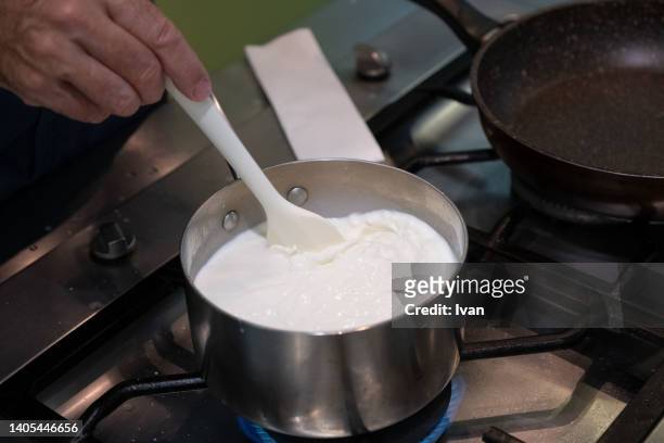 chef making make roux, creamy white sauce , bechamel in a pan - sahnesoße stock-fotos und bilder