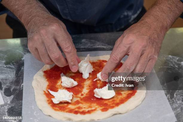 chef making traditional margaret pizza with tomato red sauce and  mozzarella  cheese - büffelmozzarella stock-fotos und bilder